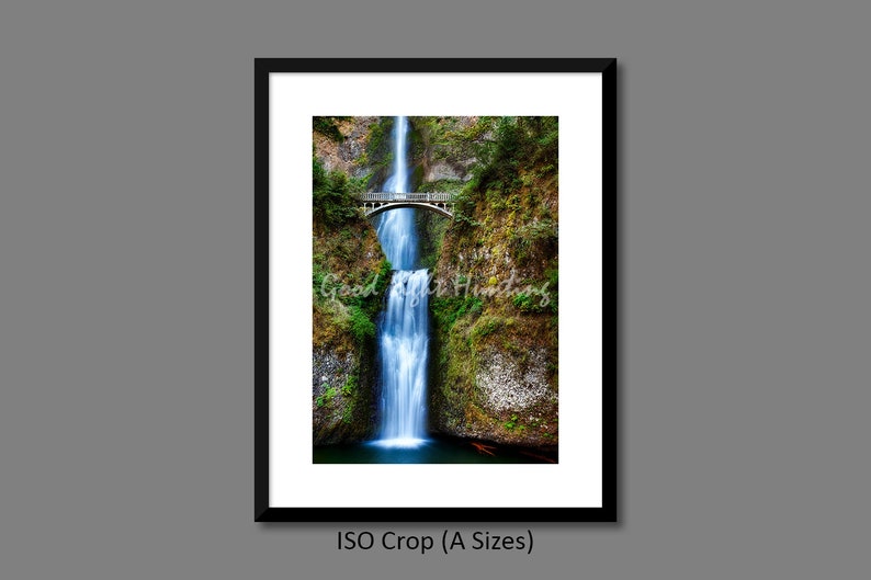 May include: A framed photograph of a waterfall cascading down a rocky cliff with a bridge over the top. The waterfall is surrounded by lush green foliage.