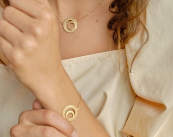 Bracelet minimaliste plaqué or ou rhodié avec pendentif double cercle. Fabriqué en Allemagne.
