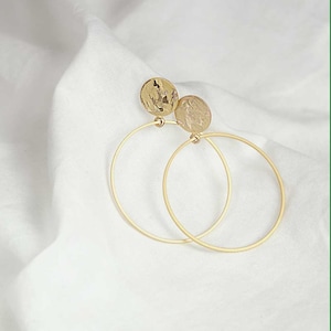 Large hoop earrings with gold-plated, rose-gold-plated, or rhodium-plated details. Matte-glossy finish.