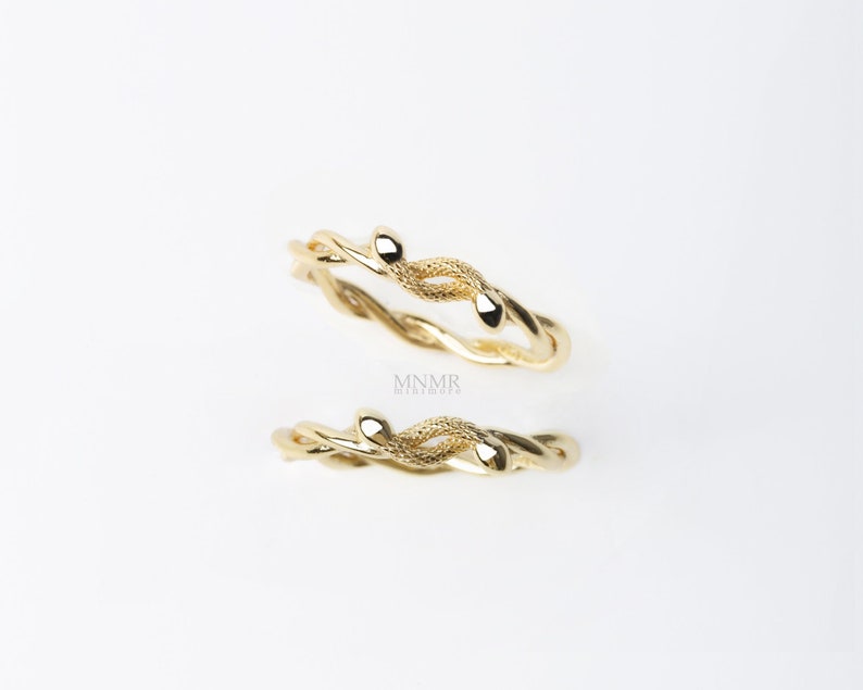 May include: Two gold rings with a twisted vine design. The rings have small, rounded leaf accents.