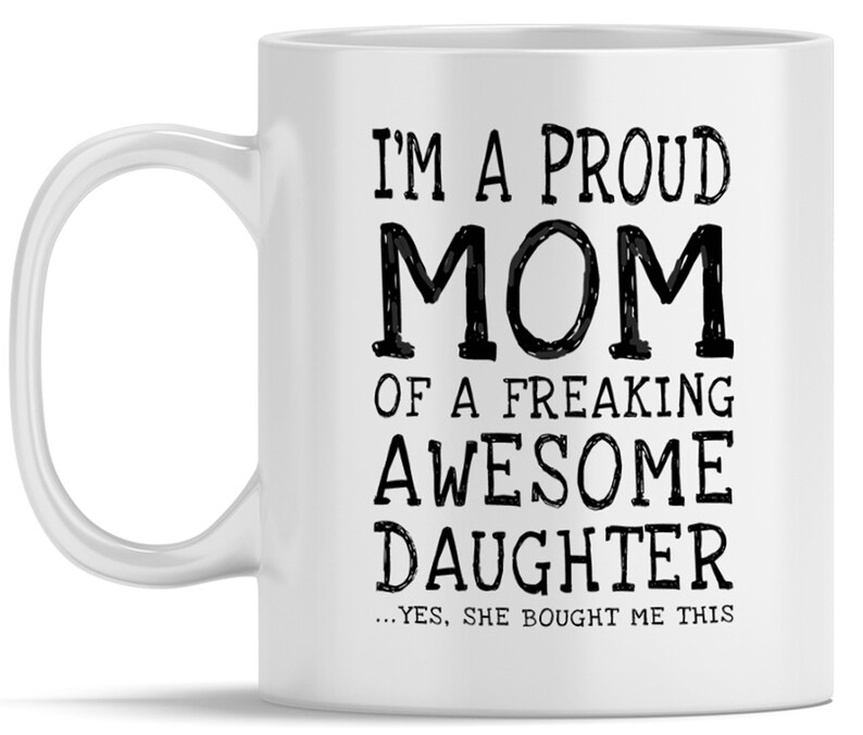 May include: White ceramic coffee mug with black text that reads "I'm a proud mom of a freaking awesome daughter...yes, she bought me this."