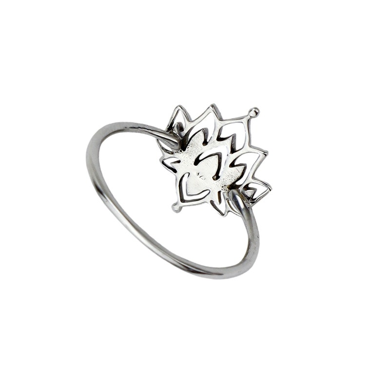 Puede incluir: Un anillo de plata con un delicado dise&ntilde;o de flor de loto. El anillo es simple y elegante, lo que lo convierte en un accesorio perfecto para cualquier ocasi&oacute;n.