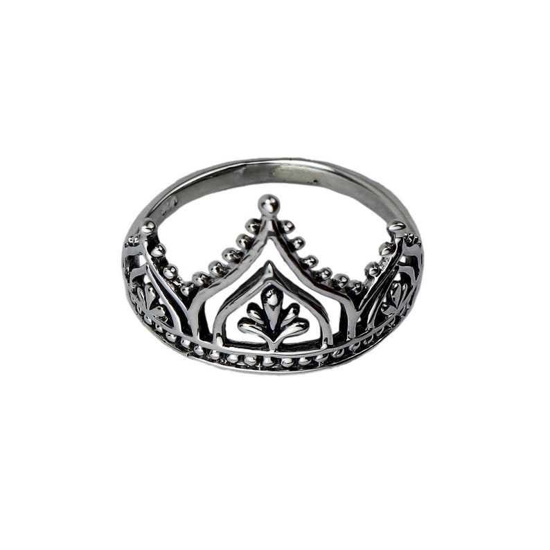 K&ouml;nnte beinhalten: Ein silberner Ring mit einem Kronendesign. Die Krone ist mit filigranen Blumenmustern und einer spitzen Spitze verziert.