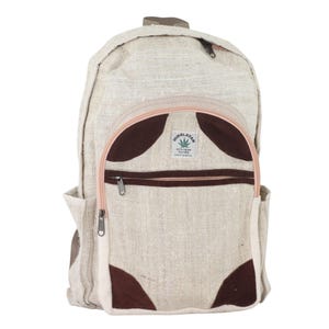 May include: A beige hemp backpack with brown and pink accents. The backpack has a zippered pocket on the front and a label that reads "HIMALAYAN 100% Hemp Two Free Made in Nepal".