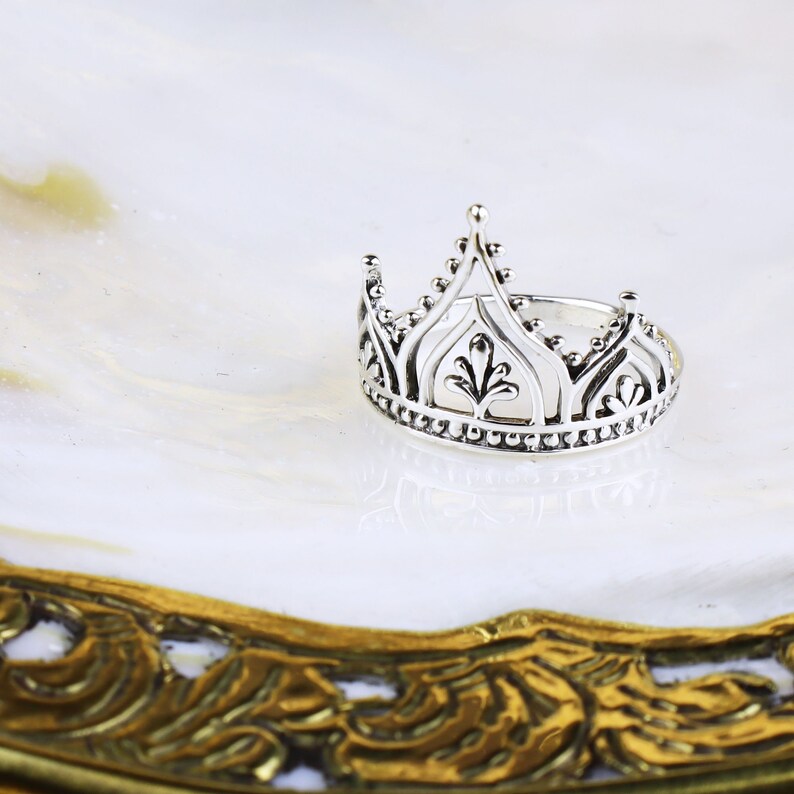 K&ouml;nnte beinhalten: Ein silberner Kronenring mit filigranen Details. Der Ring ist aus Sterlingsilber gefertigt und hat ein zartes Design.