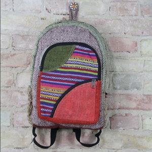May include: A multi-colored patchwork backpack with a green, red, and purple striped design. The backpack has a zippered pocket and adjustable straps.