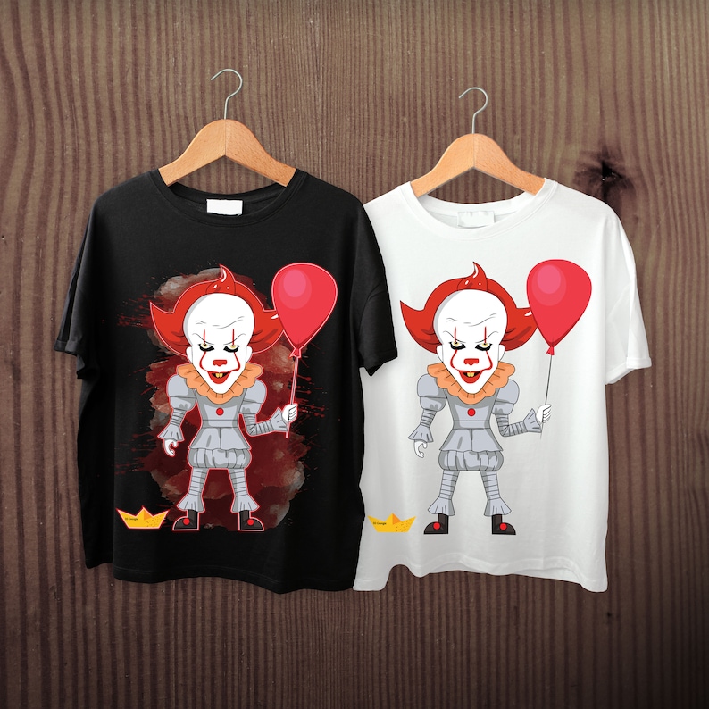 May include: Two t-shirts, one black and one white, each displaying a cartoon clown with red hair, a white face, and a red balloon. The clown is in a grey outfit and holding a red balloon. The black shirt has a red splatter design.