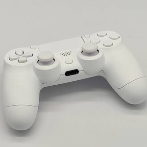 May include: A white wireless gaming controller with two analog sticks, a directional pad, and buttons. The controller has a textured grip and a USB-C port.