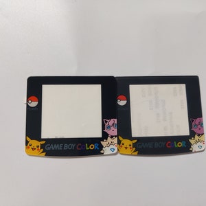 Puede incluir: Dos placas frontales negras para Game Boy Color con personajes de Pokémon. La placa de la izquierda presenta a Pikachu, Squirtle y Jigglypuff. La placa de la derecha presenta a Charmander, Bulbasaur y un Pokémon rosa con gafas. Ambas placas tienen el texto "GAME BOY COLOR" impreso en ellas.