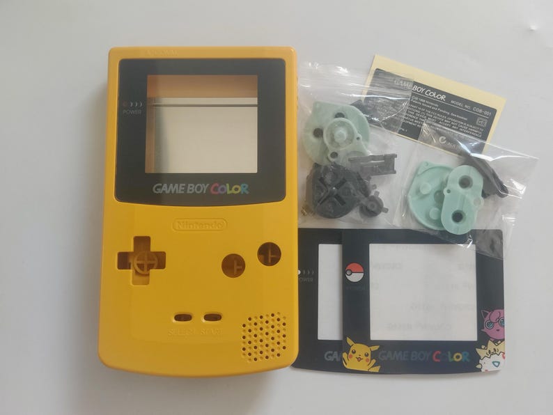 K&ouml;nnte beinhalten: Gelbe Game Boy Color Konsole mit schwarzen Akzenten, Nintendo-Logo und "GAME BOY COLOR" Text. Enth&auml;lt Ersatzteile und eine Displayschutzfolie mit Pok&eacute;mon-Grafiken. Ein Retro-Gaming-Artikel.