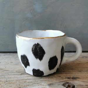 Black polka dot ceramic cup with gold rim