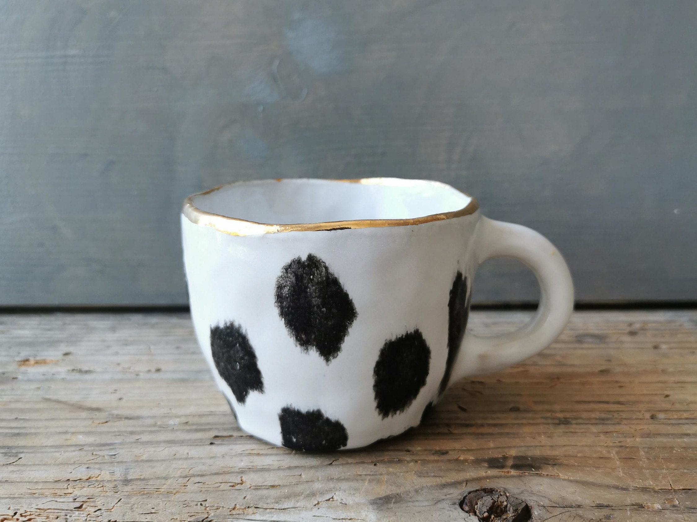 Black polka dot ceramic cup with gold rim