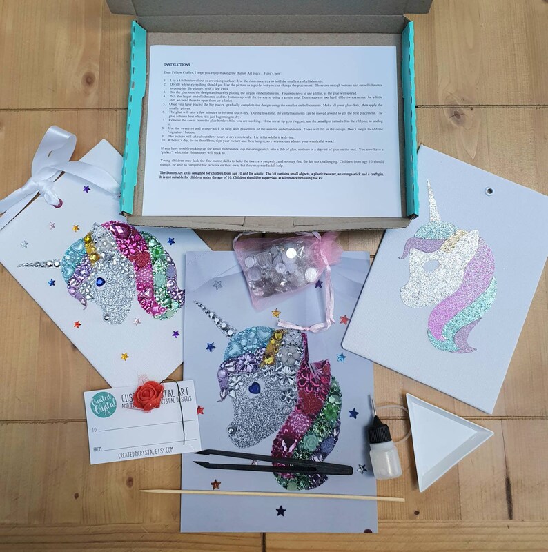 May include: A craft kit featuring three unicorn-themed art projects, a box of instructions, a small pink mesh bag of assorted embellishments, black tweezers, a small glue bottle, a white triangular tray, a wooden stick, and a gift tag.