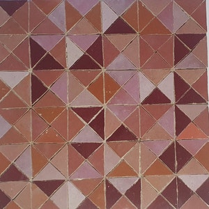 May include: A geometric pattern of terracotta, pink, and burgundy triangular tiles. The tiles are arranged in a repeating pattern, creating a visually appealing design.