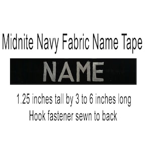 May include: Black fabric name tape with white lettering that reads "NAME". The tape is 1.25 inches tall by 3 to 6 inches long. It has a hook fastener sewn to the back.