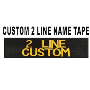 May include: Black name tape with the text "2 LINE CUSTOM" embroidered in yellow thread.
