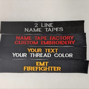 May include: Four black fabric name tapes with white, red, and yellow embroidery. The top tape reads "2 Line Name Tapes". The second tape reads "Name Tape Factory Custom Embroidery". The third tape reads "Your Text Your Thread Color". The bottom tape reads "EMT Firefighter".