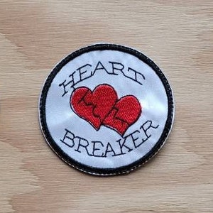 May include: Three white, round, embroidered patches with black trim. Each patch features a red broken heart with the text "HEART BREAKER" in black.