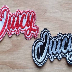 May include: Two embroidered patches with the word "Juicy" in a stylized font. The top patch is red with white outlining, and the bottom patch is black with silver outlining.