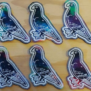 May include: Ten embroidered iron-on patches of pigeons with a tie-dye effect in shades of blue, green, purple, and pink.