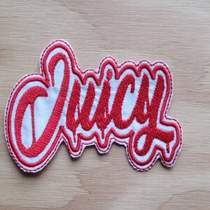 May include: Red embroidered patch with the word "Juicy" in a white outline.