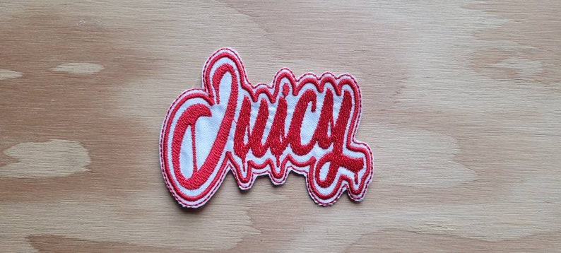 May include: Red embroidered patch with the word "Juicy" in a white outline.