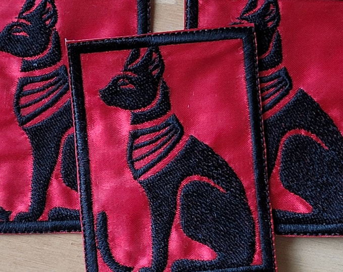 Black Egyptian Cat handmade sew on patch embroidered on red satin fabric.