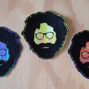 May include: Three embroidered patches featuring a psychedelic portrait of a man with long hair and glasses. The patches are in different color schemes: green, blue, and yellow.