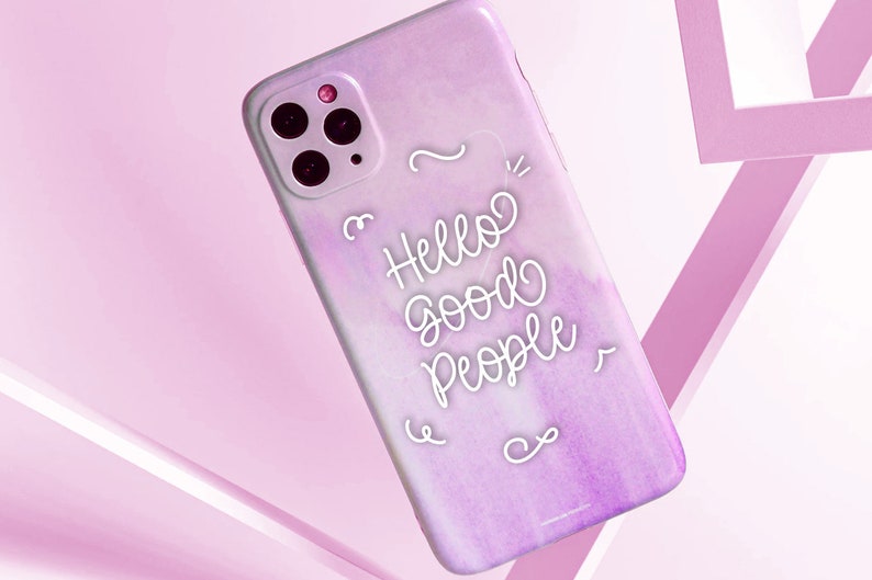 K&ouml;nnte beinhalten: Eine rosa und lilafarbene Aquarell-Handyh&uuml;lle mit einem wei&szlig;en Design, auf dem "Hello Good People" steht.