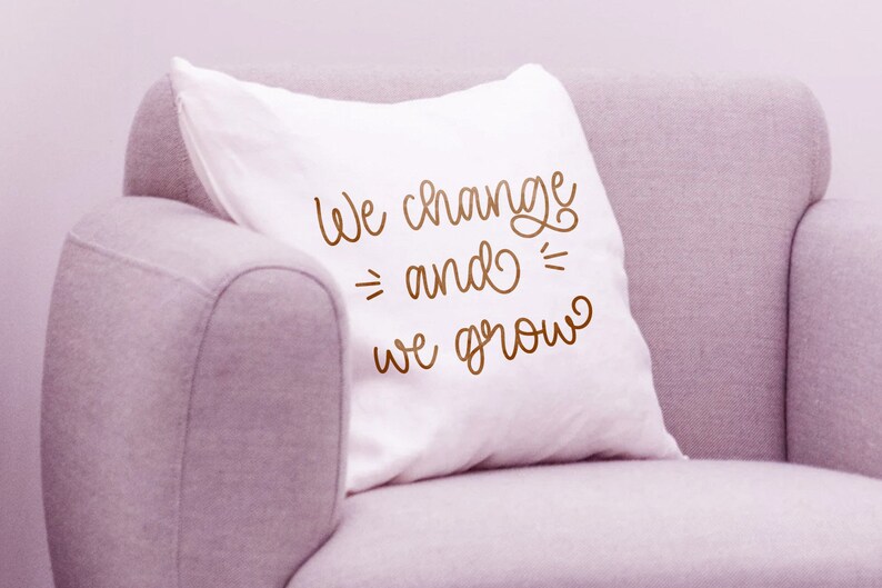 K&ouml;nnte beinhalten: Ein wei&szlig;es Kissen mit dem Text "We change and we grow" in brauner Kursivschrift.