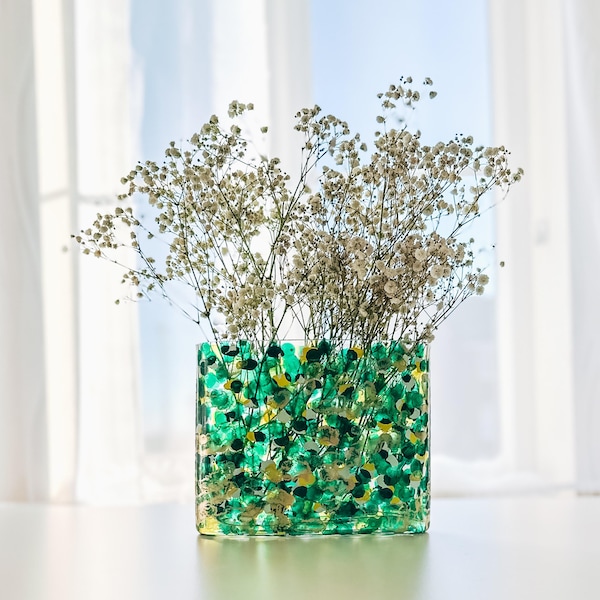 Smaragdgroene en gouden glazen vaas voor bloemen, abstract bloemendecor