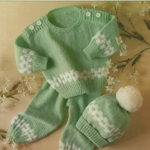 Könnte beinhalten: Ein grünes und weißes Doppelstrick-Set für Babys bestehend aus Pullover, Hose und Mütze. Das Set ist aus weichem, kuscheligem Garn gefertigt und perfekt für einen Babyjungen oder ein Babymädchen. Das Set ist in den Größen 46-61 cm erhältlich.