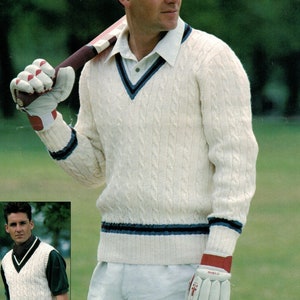 Könnte beinhalten: Ein weißer, gemaschter Strickpullover mit blauem und rotem Besatz. Der Pullover hat einen V-Ausschnitt und wird von einer Person getragen, die einen Cricket-Schläger hält. Der Text "4 PLY AND DOUBLE KNITTING" befindet sich oben im Bild.