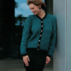May include: A teal and black houndstooth cardigan with black buttons and a black skirt.