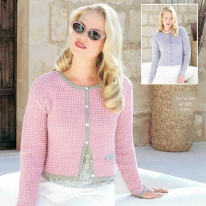 Op de afbeelding: Een roze en grijze gebreide cardigan met knoopsluiting. De cardigan heeft een wafelstructuur en een grijze rand. Het model draagt een witte broek en een zonnebril.