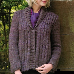 Puede incluir: Un cárdigan de punto marrón con cuello ancho y cierre de botones. El cárdigan tiene un patrón de punto texturizado y lo lleva puesto una persona con el pelo rubio.