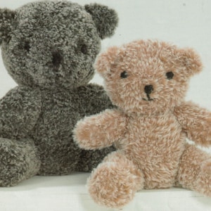 Peut inclure: Deux ours en peluche, l'un gris et l'autre brun clair, assis côte à côte. Les deux ours ont des yeux noirs et un nez noir.