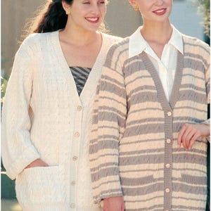 Könnte beinhalten: Zwei Frauen tragen Strickjacken. Eine ist cremefarben mit Zopfmuster und Taschen. Die andere ist eine gestreifte Strickjacke in Grau und Creme. Beide Strickjacken haben einen V-Ausschnitt und Knopfverschlüsse.