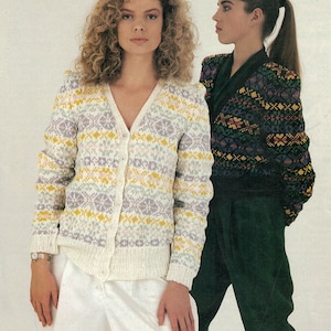 May include: Two women modelling knitted cardigans with colourful Fair Isle patterns. The cardigan on the left is white with yellow, purple, and green accents. The cardigan on the right is black with red, yellow, green, and blue accents. The text "Rowan Yarns" and "Designer Collection" is visible at the top and bottom of the image.