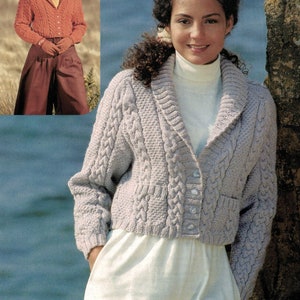 May include: A light gray, cropped cable-knit cardigan with a shawl collar and button closure. The sweater has pockets and is paired with white pants. A smaller image shows a similar orange cardigan.