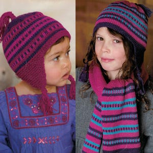 May include: Two children wearing knitted winter hats and scarves. The hats and scarves are in shades of purple, pink, and teal, with a striped pattern. The hats have ear flaps and tassels. The children are wearing blue and gray tops.