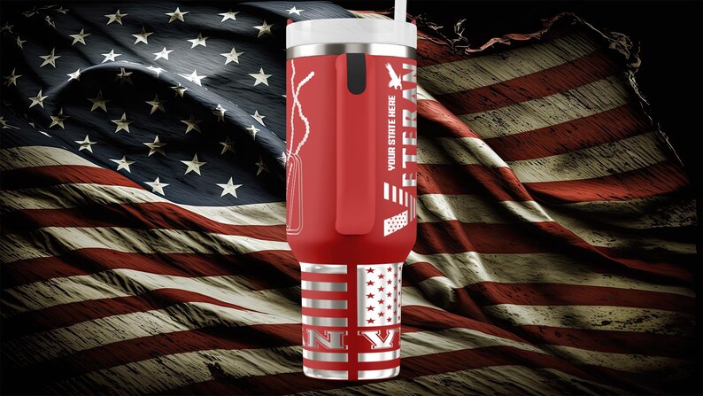 以下が含まれることがあります： 白い蓋とストローが付いた赤い断熱タンブラー。ドッグタグ、ワシ、そして「VETERAN」の文字がデザインされています。タンブラーの底には「NY」の文字が入った旗のデザインがあります。背景はアメリカ国旗です。