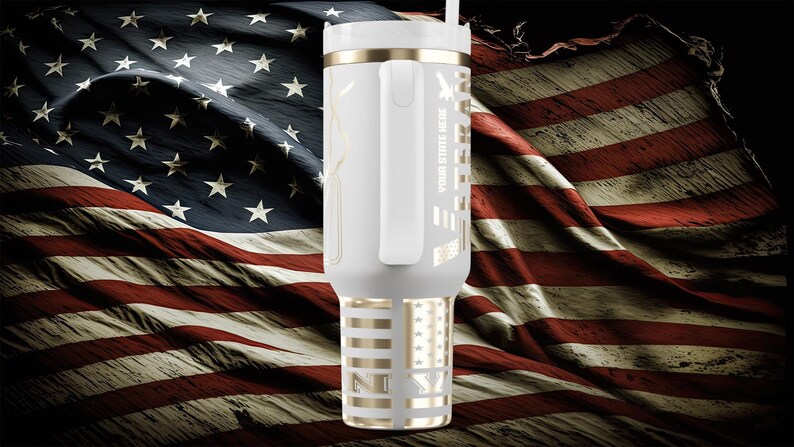 以下が含まれることがあります： ゴールドのアクセントとハンドルが付いた白いタンブラー。アメリカ国旗のデザインと「YOUR STATE HERE」の文字が特徴です。タンブラーにはストローと蓋が付いています。背景はアメリカ国旗です。