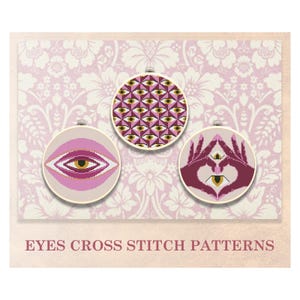 Puede incluir: Tres patrones de punto de cruz con ojos en diferentes estilos. El primer patrón es un patrón repetitivo de ojos con acentos dorados. El segundo patrón es un solo ojo con un fondo rosa. El tercer patrón es un par de manos formando una forma de corazón con un ojo en el centro.