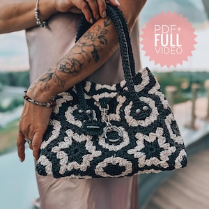 Könnte beinhalten: Eine gehäkelte Tragetasche in Schwarz und Weiß mit einer silbernen Kette und einem schwarzen Etikett mit der Aufschrift "Handmade with love".