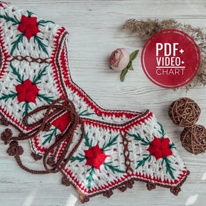 May include: A white, red, and green crocheted garment with a floral design. The garment has a brown tie and trim. The image also includes a red circle with the text "PDF+ VIDEO+ CHART".