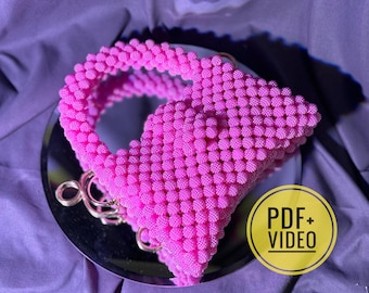 May include: A pink beaded handbag with a gold chain strap. The bag is made of small, round beads and has a unique, modern design.