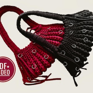 Op de afbeelding: Twee handgemaakte macramé tassen, één rode en één zwarte, worden getoond. Elke tas heeft een lusvormige handgreep en is versierd met zilveren metalen ringen. De tassen worden gepresenteerd tegen een neutrale achtergrond, met een cirkelvormige afbeelding met de tekst "PDF+ VIDEO".