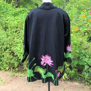 May include: Black kimono with green and pink embroidered lotus flowers on the hem.
