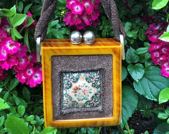 May include: A vintage yellow and brown beaded purse with a floral embroidered design and silver-toned clasps.